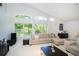 Bright and airy living room featuring large windows, high ceilings, and comfortable furnishings at 1903 Curry Rd, Lutz, FL 33549
