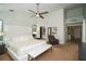 Bright main bedroom featuring a ceiling fan, white walls, carpet and a large, upholstered headboard at 1903 Curry Rd, Lutz, FL 33549
