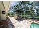 Screened-in patio with a built-in outdoor kitchen and dining bar top at 1903 Curry Rd, Lutz, FL 33549