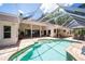 The backyard features a pool, covered patio, and outdoor kitchen, perfect for entertaining at 1903 Curry Rd, Lutz, FL 33549