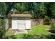 Backyard shed with a wooden walkway and fence, offering practical storage in a charming outdoor setting at 1903 Curry Rd, Lutz, FL 33549