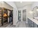 Modern bathroom featuring walk-in closet, dual sink vanity with marble counters, and glass shower at 1914 Elk Spring Dr, Brandon, FL 33511