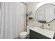 Bright bathroom featuring a round mirror, modern sink, and tiled shower at 1914 Elk Spring Dr, Brandon, FL 33511