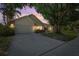 Traditional home at dusk with a large driveway, a well-manicured lawn and mature landscaping at 1914 Elk Spring Dr, Brandon, FL 33511