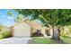 Charming single-story home featuring a brick facade, attached garage, and mature trees at 1914 Elk Spring Dr, Brandon, FL 33511
