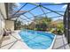 Enclosed pool area with outdoor seating, lush greenery, and clear blue water at 1914 Elk Spring Dr, Brandon, FL 33511