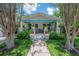 Front exterior of a charming home featuring a cozy porch, blue trim, and vibrant landscaping at 204 E North St, Tampa, FL 33604