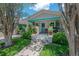 Charming bungalow featuring well-maintained landscaping and a covered front porch with a pop of turquoise accents at 204 E North St, Tampa, FL 33604