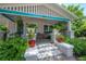Cozy front porch with colorful plants, comfortable seating, and classic white and turquoise trim at 204 E North St, Tampa, FL 33604