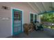 Inviting front porch with a comfortable wicker chair, side table, and relaxing porch swing at 204 E North St, Tampa, FL 33604