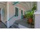 Relaxing front porch featuring classic white and turquoise trim, potted plants, and seating at 204 E North St, Tampa, FL 33604