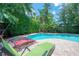 A backyard pool surrounded by lush tropical foliage and a brick paver deck offers a private outdoor retreat at 204 E North St, Tampa, FL 33604