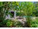 Backyard shed leading to a pool and outdoor dining space, surrounded by vibrant foliage at 204 E North St, Tampa, FL 33604