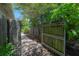 Backyard gate offers private access to a landscaped yard with a walkway and greenery at 204 E North St, Tampa, FL 33604