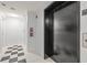 Hallway with a black and white checkered tile floor that leads to an elevator, next to a wall-mounted fire extinguisher at 205 5Th N Ave # 501, St Petersburg, FL 33701