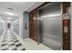 Hallway with elevator access featuring tiled walls, a fire extinguisher, and 'use stairs' sign at 205 5Th N Ave # 501, St Petersburg, FL 33701