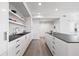 Modern kitchen featuring white cabinets, open shelving, and stainless steel appliances at 205 5Th N Ave # 501, St Petersburg, FL 33701
