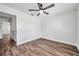 This bedroom features a ceiling fan and wooden floors at 2078 Madrid N Ct, Clearwater, FL 33763