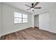 This bedroom features a ceiling fan, wooden floors, a window, and a closet at 2078 Madrid N Ct, Clearwater, FL 33763