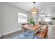 Dining area features a wood table, stylish chairs, modern light fixture, and view of the living room at 2078 Madrid N Ct, Clearwater, FL 33763