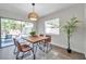Dining area with wood table, stylish chairs, modern light fixture, and a view of the backyard at 2078 Madrid N Ct, Clearwater, FL 33763