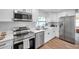Modern kitchen with stainless steel appliances, white cabinets, and stylish backsplash at 2078 Madrid N Ct, Clearwater, FL 33763