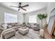 Inviting living room featuring a comfortable sofa, ottoman, and modern ceiling fan at 2078 Madrid N Ct, Clearwater, FL 33763