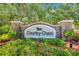Elegant stone community entrance sign for Country Chase with lush landscaping and mature trees at 2078 Madrid N Ct, Clearwater, FL 33763