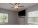 Bedroom with ceiling fan, hardwood floors, natural light from two windows, and mounted TV at 2104 E Navajo Ave, Tampa, FL 33612