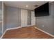 Bedroom featuring hardwood floors, closet, mounted TV and natural light from one window at 2104 E Navajo Ave, Tampa, FL 33612