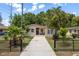 Charming home with a well-manicured lawn and black metal fence at 2104 E Navajo Ave, Tampa, FL 33612