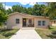 Charming single-story home with a well-maintained front yard and a cozy entryway seating area at 2104 E Navajo Ave, Tampa, FL 33612