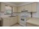 Well-lit kitchen with white appliances, tile floors, and ample counter space, perfect for cooking enthusiasts at 2104 E Navajo Ave, Tampa, FL 33612