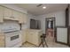 Bright kitchen with white appliances, tile floors, and a view into the living room, perfect for cooking enthusiasts at 2104 E Navajo Ave, Tampa, FL 33612