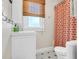 Bright bathroom with floral shower curtain, window with bamboo shade and patterned floor tile at 221 13Th Ne Ave, St Petersburg, FL 33701
