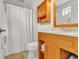 Bright bathroom features light wood vanity, decorative shower curtain, and neutral colored tile flooring at 221 13Th Ne Ave, St Petersburg, FL 33701