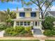 Charming yellow two-story home with a metal roof, inviting front porch and lush landscaping in a desirable neighborhood at 221 13Th Ne Ave, St Petersburg, FL 33701