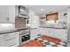 Modern kitchen features stainless steel appliances, white cabinets, black and white checkered floors, and a stylish backsplash at 221 13Th Ne Ave, St Petersburg, FL 33701