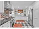 Bright kitchen featuring black and white tile, stainless steel appliances, and a colorful backsplash at 221 13Th Ne Ave, St Petersburg, FL 33701