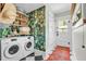 Convenient laundry room featuring modern washer and dryer, tropical wallpaper and black & white tile floor at 221 13Th Ne Ave, St Petersburg, FL 33701