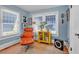 Living room with blue walls, modern yellow cabinet, and sleek orange lounge chair at 221 13Th Ne Ave, St Petersburg, FL 33701