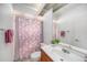Well-lit bathroom with a vanity, mirror, and shower with decorative floral curtain at 2632 Tung Dr, Holiday, FL 34691