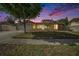 Charming one story home with attached garage and large front tree in the yard, enhanced by sunset at 2632 Tung Dr, Holiday, FL 34691