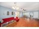 Open living and dining area showcasing the red couch set, wood floors, and natural light at 2632 Tung Dr, Holiday, FL 34691