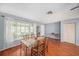 Bright living room featuring a glass dining table, hardwood floors, and great natural light through big windows at 2632 Tung Dr, Holiday, FL 34691