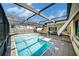 Enclosed pool area featuring a tiled patio and shaded seating area at 2632 Tung Dr, Holiday, FL 34691