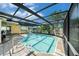Inviting screened-in pool area with clear water and a tiled patio at 2632 Tung Dr, Holiday, FL 34691