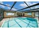 Sparkling pool area with a covered patio for outdoor lounging and sunshades at 2632 Tung Dr, Holiday, FL 34691