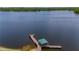 Aerial close-up of a charming wooden pier with a covered seating area extending into a serene lake at 2712 Spring Meadow Dr, Plant City, FL 33566