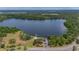 Expansive aerial view showcasing a tranquil lake surrounded by lush greenery, park, and community features at 2712 Spring Meadow Dr, Plant City, FL 33566